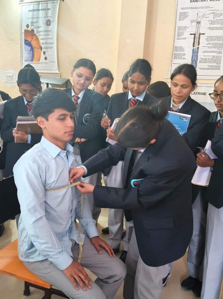 Nursing student undergoing height and weight assessment for BMI calculation on a clinical stadiometer during a health assessment practical